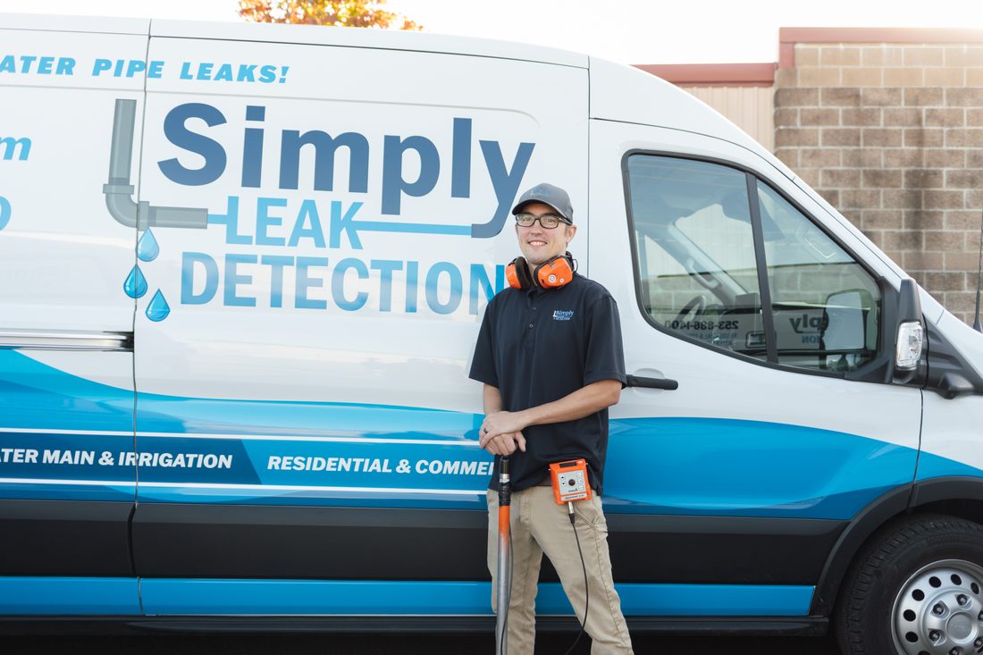 Simply Leak Detection technician with acoustic leak detection equipment beside a company service van